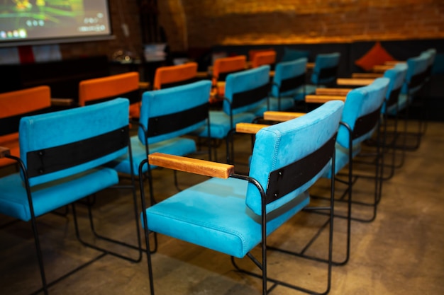 Red and blue chairs in the dark hall of a small cinema