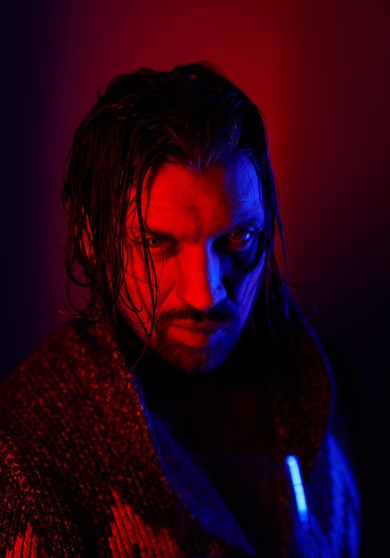 Red blue light latin man portrait looking to the camera with confidence