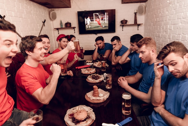 Squadra rossa e blu sono seduti al bar dello sport.