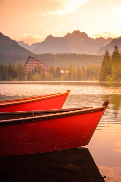 Red boats on Lake Strbske pleso Morning view of the High Tatras National Park Slovakia Europe