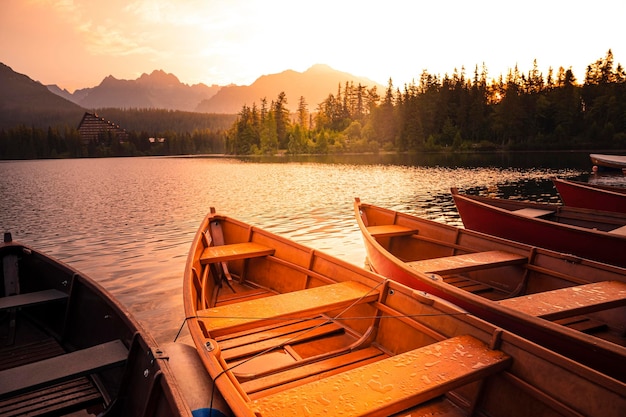 Red boats on Lake Strbske pleso Morning view of the High Tatras National Park Slovakia Europe