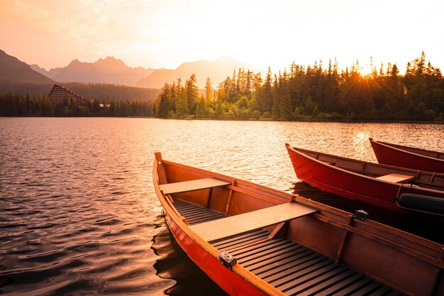 Red boats on Lake Strbske pleso Morning view of the High Tatras National Park Slovakia Europe