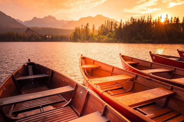 Red boats on Lake Strbske pleso Morning view of the High Tatras National Park Slovakia Europe