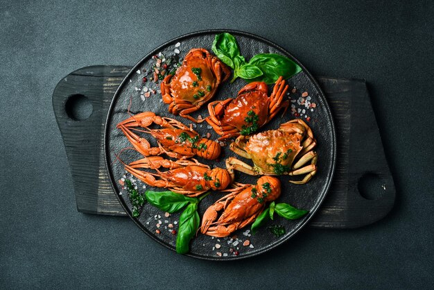 Red boiled crabs and crayfish with basil and garlic on a plate Top view Advertising restaurant photo