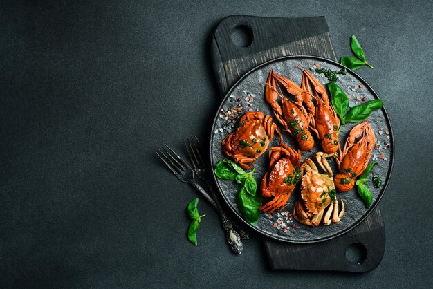 Red boiled crabs and crayfish with basil and garlic on a plate Top view Advertising restaurant photo