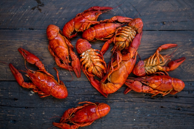 Red boiled crawfishes on table in rustic style, closeup. Lobster closeup.