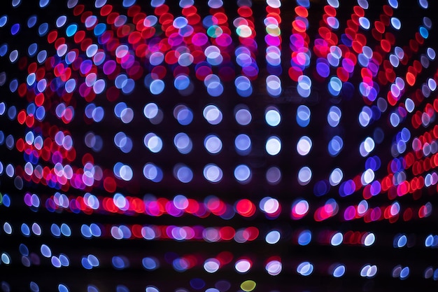 Foto bokeh rosso sfondo festivo astratto il bagliore di molte piccole lampadine