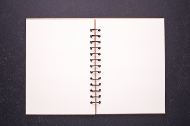 Red book with blank empty cover on black stone table background. Top view