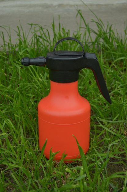 Photo a red bottle with a black handle sits in the grass.