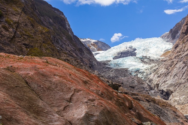 Foto masso rosso su uno sfondo di un ghiacciaio vista del ghiacciaio franz joseph in nuova zelanda