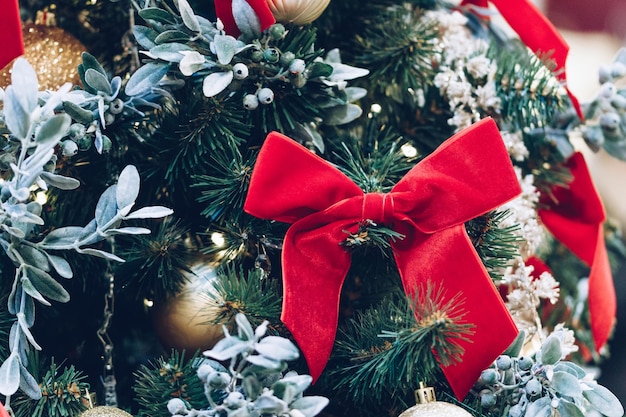 Red bow christmas balls and garlands on a christmas tree closeup