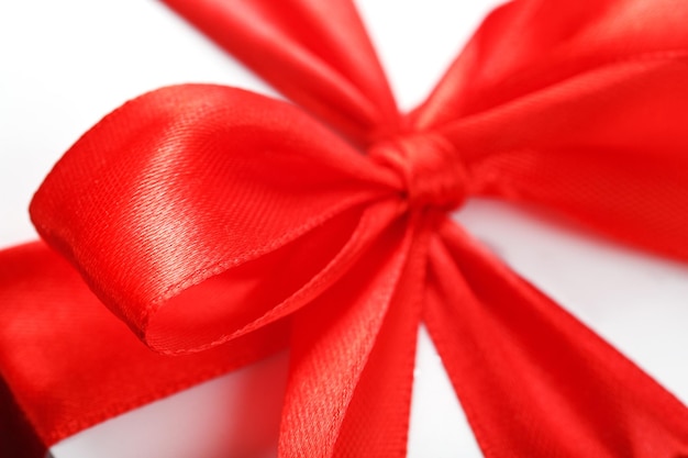 Red bow on a gift made of fabric on a white background. Close-up