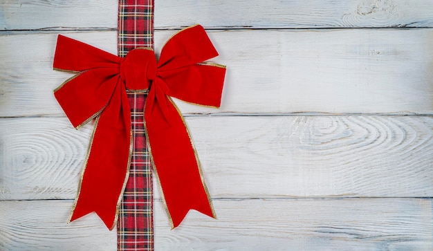 red bow on a wooden light background christmas background photo for a postcard or gift bag