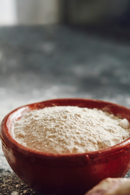 Red bowl of flour on blurred background