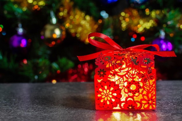 Red box with a gift glowing from the inside surprise under the Christmas tree