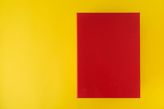 Красная коробка на желтом фоне, вид сверху. Красный прямоугольник.