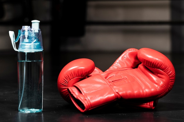 Red boxing gloves close-up next to water bottle