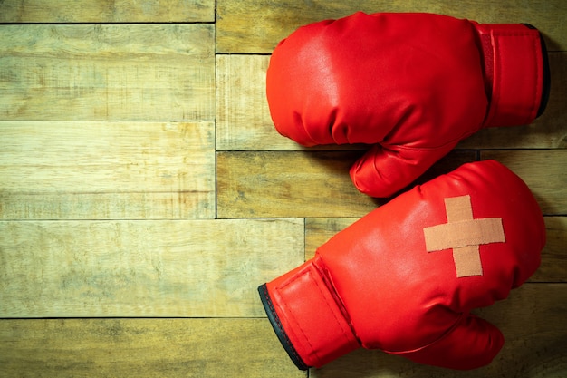 Red boxing gloves placed on wooden floor at the gym