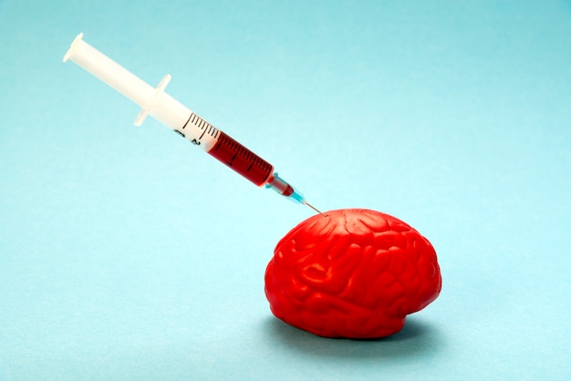 Photo red brain on blue with a nootropic syringe.