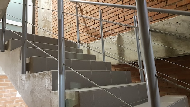 Red brick building with a modern staircase in a loft style with
metal railing. stairs adorn the building. modern stairwell. steel
railing. staircase in perspective.