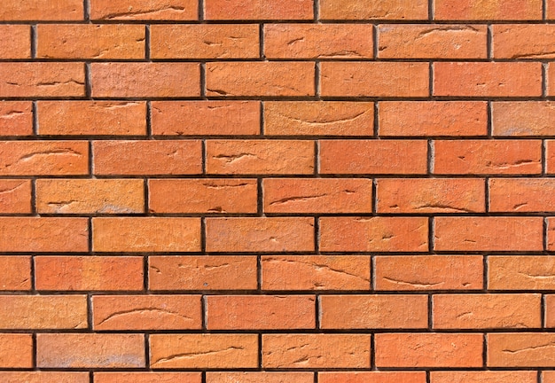 Red brick wall. Decorative brick with artificial defects and cracks.