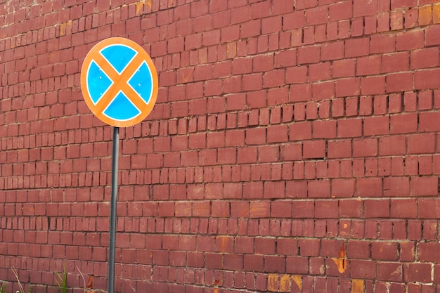 Red brick wall and road round crossed out sign