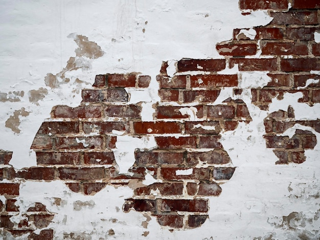 A red brick wall with peeling paint