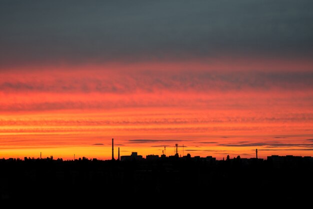 都市の赤い明るい夕日。都市の産業景観