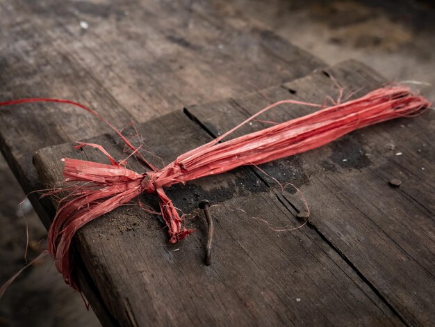 red and broken raffia rope tied to a wooden chair