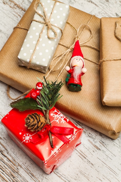 Red and brown christmas gifts on a worn out white wooden table