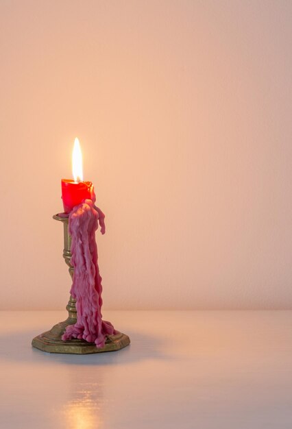Red burning candle in white interior
