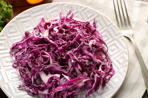 Photo red cabbage salad served on plate closeup