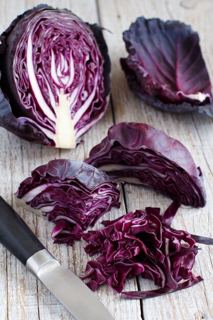 Red cabbage with a knife on a wooden table