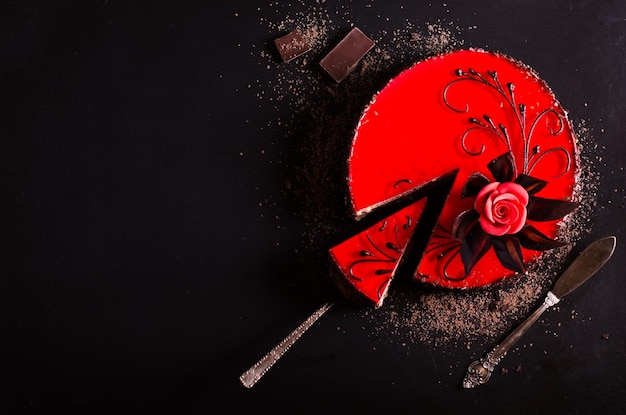 Red cake with rose chocolate flower on dark background Free space for your text Selective focus