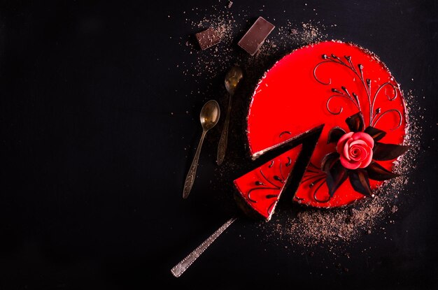 Red cake with rose chocolate flower on dark background Free space for your text Selective focus