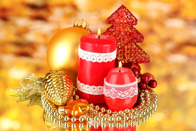 Red candle with christmas decoration on bright background