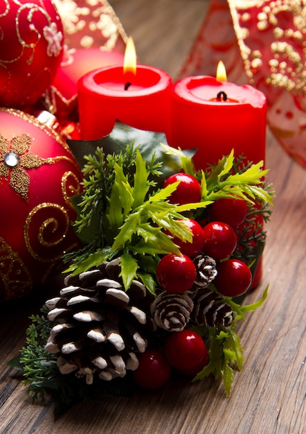 red candle with pine on wood