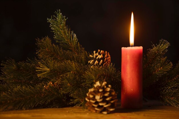 Red candle with twigs of the spruce