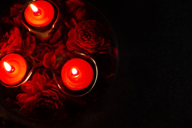 Red candles in a candlestick on a black background top view