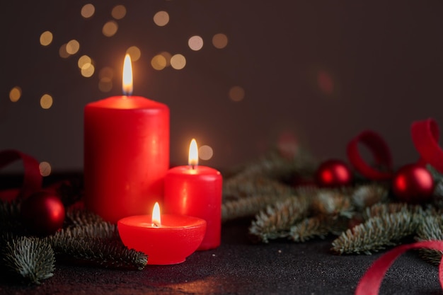 red candles on dark background with bokeh lights horizontal with copyspace