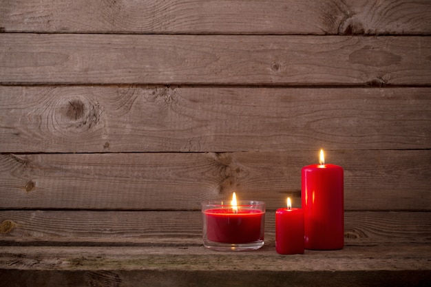 Red candles on dark wooden background