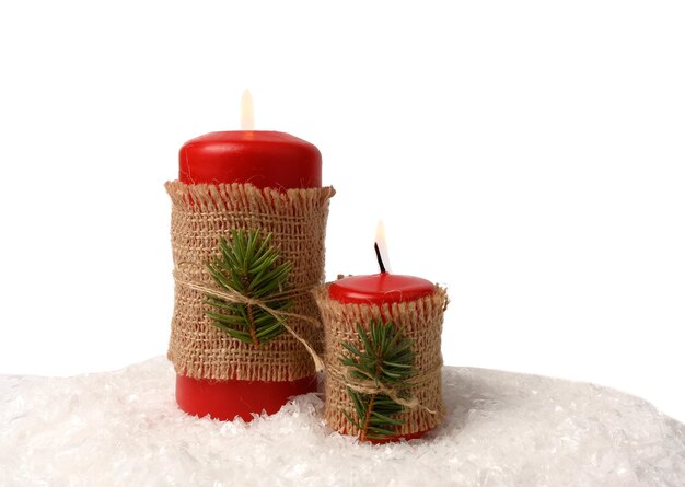 Red candles on white snow. Christmas decorations. On white background.