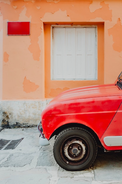 Foto macchina rossa dalla parete arancione