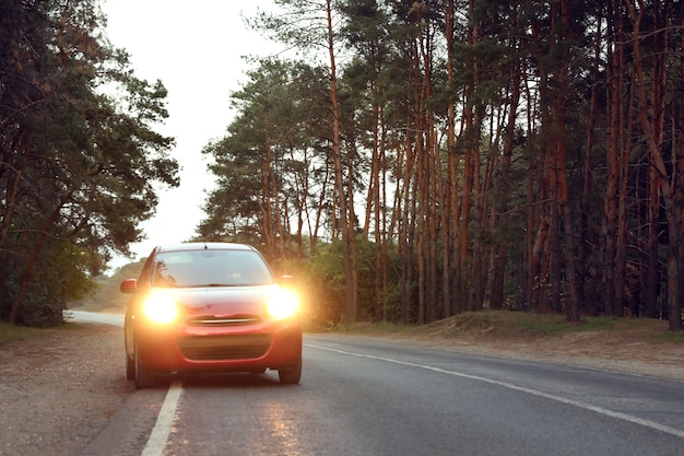 Photo red car parked near forest road trip