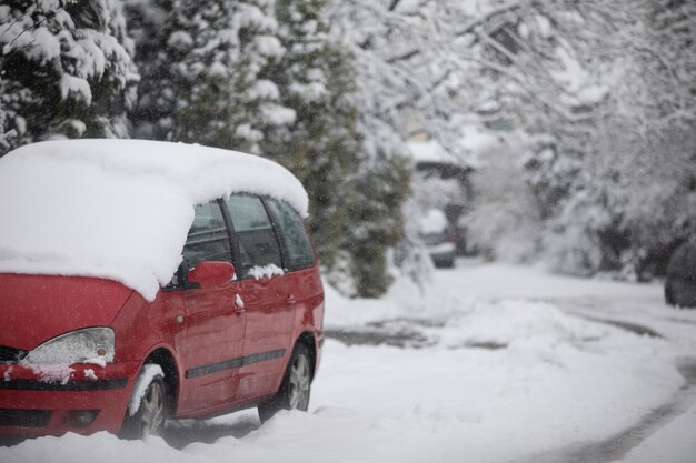 Red car parked on a very snowy estate road