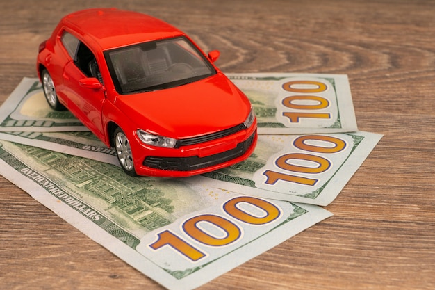 Red car with dollars banknotes, rich auto service or repair concept