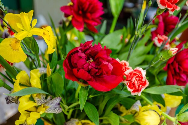 写真 他の花の中で赤いカーネーションの花束