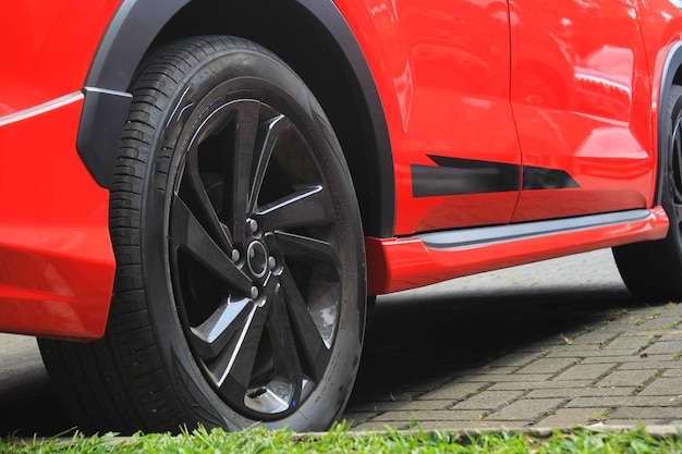 赤い車のホイールと黒い金属ベルグとゴム製タイヤ