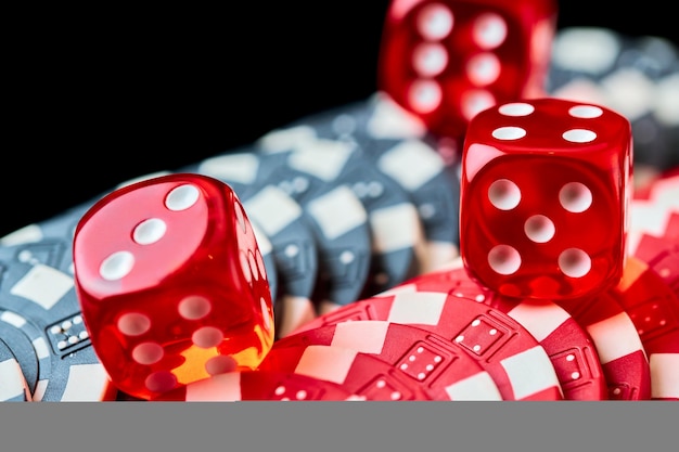 Red casino dice and chips on black table