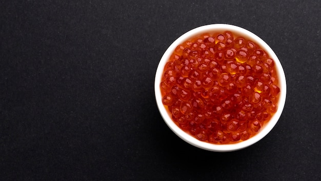 Red caviar on black background
